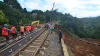 Petugas PT KAI memperbaiki rel yang longsor di Kampung Maseng Bogor. (Achmad Sudarno/Liputan6.com)