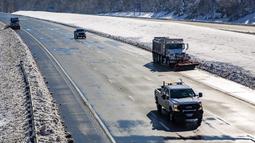 Kendaraan bajak salju mendorong salju ke sisi utara Interstate 95 di Spotsylvania County, Virginia, Selasa (4/1/2022). Ratusan pengendara terdampar setelah badai musim dingin mengganggu lalu lintas dan membuat beberapa pengemudi terjebak selama hampir 24 jam dalam suhu beku. (AP Photo/TRISTAN LOREI)