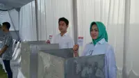 Calon Wali Kota incumbent Tangsel, Airin Rachmi Diany, memberikan hak suaranya di TPS 17 bersama anak pertamanya. (Liputan6.com/Naomi Trisna)