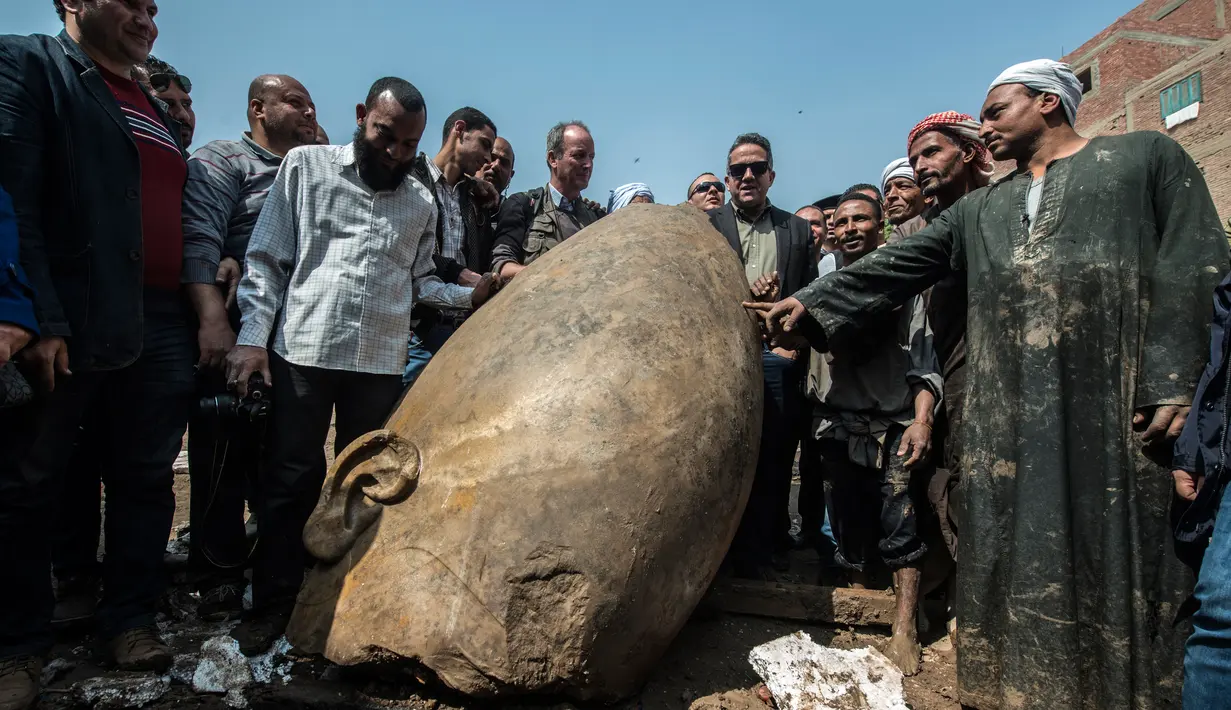 Warga melihat dekat pecahan patung yang ditemukan oleh tim arkeolog Jerman-Mesir di distrik Mattarya, Kairo, Kamis (9/3). Diduga pecahan patung yang digali di sekitar Kuil Ramses II tersebut berasal dari dinasti XIX (1295-1185 SM)