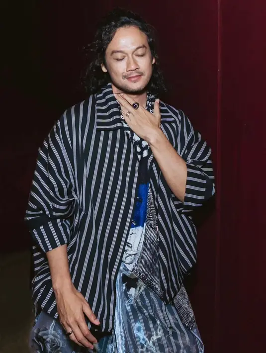 Penampilan Dwi Sasono terdiri dari atasan bermotif abstrak campuran, luaran berupa jaket, dan celana gombrong lurik. [Foto: Instagram/dwisasono]