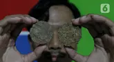 Salah satu pemuda perajin menunjukkan hasil olahan eceng gondok di kawasan Plaju, Palembang, Sumatra Selatan, Senin (26/5/2025). (Liputan6.com/Herman Zakharia)