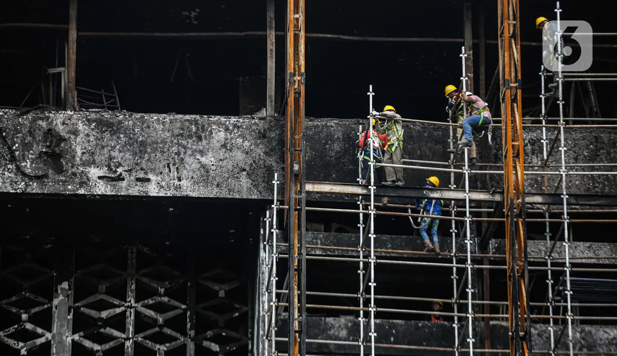 Pekerja memasang 'scaffolding' atau struktur besi untuk melakukan perbaikan Gedung Kejaksaan Agung, Jakarta, yang hangus terbakar, Rabu (7/10/2020).  DPR RI menyepakati penambahan anggaran Kejagung sebesar Rp 350 miliar untuk merenovasi gedung utama yang terbakar hebat. (Liputan6.com/Faizal Fanani)