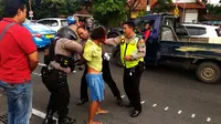 Pria pembawa bom molotov ditangkap personel Reskrim Polrestabes Surabaya di depan Gedung Grahadi. (Liputan6.com/Dhimas Prasaja)