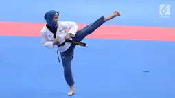 Atlet Taekwondo putri Indonesia, Defia Rosmaniar saat beraksi melawan Salahshouri Marjan (Iran) pada Final Women Individual Poomsae di JCC, Jakarta, Minggu (19/8). Defia Rosmaniar berhasil meraih emas. (Liputan6.com/Helmi Fithriansyah)