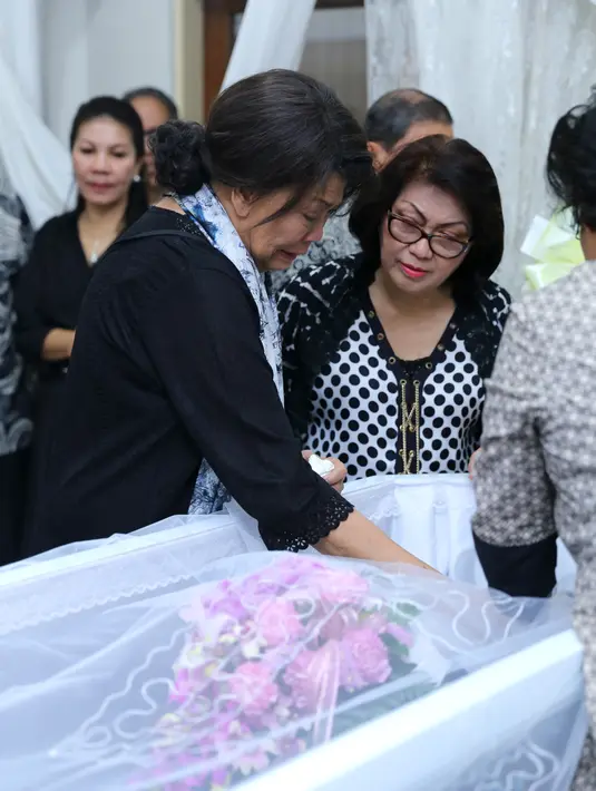 Rima Melati, berdiri disisi peti berwarna putih. Air mata dukanya terus mengalir.