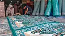 Pekerja mengecek karpet masjid pesanan pembeli di sebuah toko di kawasan Tanah Abang, Jakarta, Kamis (16/3/2023). (Liputan6.com/Angga Yuniar)