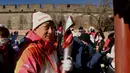 Aktor Jackie Chan memegang Obor Olimpiade di Tembok Besar Badaling pada hari kedua estafet obor di Beijing pada 3 Februari 2022, sehari sebelum dimulainya Olimpiade Musim Dingin Beijing 2022. (AFP/Noel Celis)