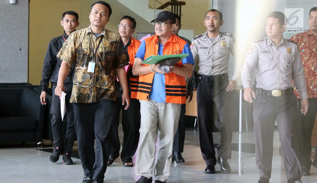 Staff Khusus Bupati Kudus, Agus Soeranto (tengah) dikawal petugas usai pemeriksaan terkait dugaan suap pengisian jabatan perangkat daerah di lingkungan Pemkab Kudus, Gedung KPK, Jakarta, Sabtu (27/7/2019). KPK juga menetapkan Bupati Kudus, M Tamzil sebagai tersangka. (Liputan6.com/Helmi Fithriansyah