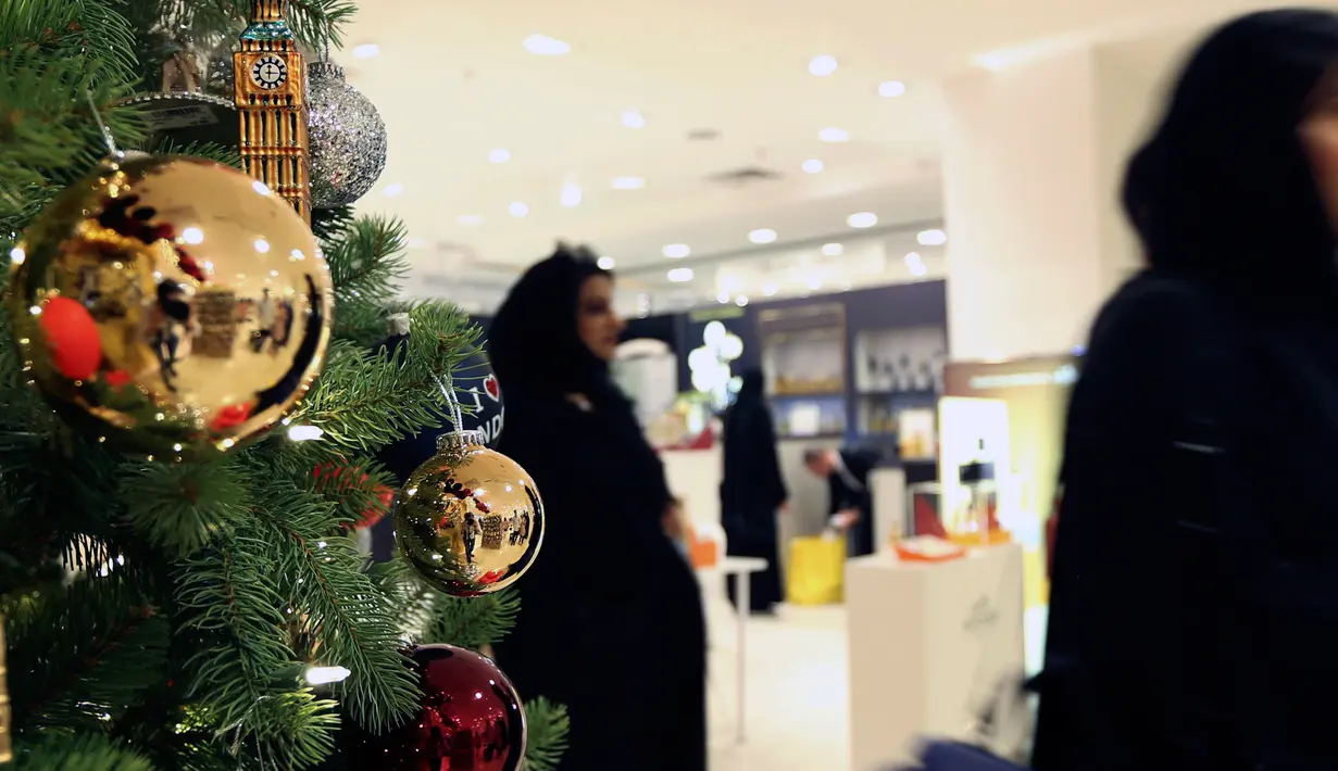 Pengunjung melintasi pohon natal di toko Selfridges, London, Senin (6/8). Kebijakan membuka gerai ornamen natal jauh hari sebelum natal tiba ternyata untuk memfasilitasi para turis dari luar negeri yang sedang berkunjung ke London. (AP/Robert Stevens)