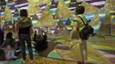 Pengunjung melihat karya dari pelukis Austria, Gustav Klimt dalam pameran seni proyeksi di galeri l'Atelier des Lumieres di Paris, Prancis (24/4). Dalam pameran ini pengunjung bisa menikmati lukisan dalam bentuk digital. (AP/Michel Euler)