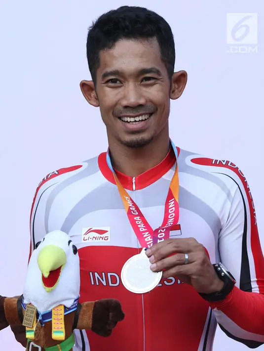 Atlet ParaCycling, M Fadli Immamuddin tersenyum mem[erlihatkan medali perak nomor Mens C4 Individual Time Trial Road Race Asian Para Games 2018 di Sirkuit Sentul, Bogor, Senin (8/10). (Liputan6.com/Helmi Fithriansyah)