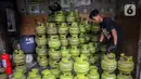 Pekerja menata tabung liquefied petroleum gas (LPG) 3 Kg di sebuah agen di kawasan Jakarta, Rabu (27/12/2023). Pemerintah mendorong penyaluran LPG 3 Kg lebih tepat sasaran dengan menggunakan Kartu Tanda Penduduk (KTP) mulai 1 Januari 2024. (Liputan6.com/Angga Yuniar)