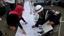 Warga yang melintas di kawasan Bundaran HI membubuhkan tanda tangannya saat aksi "Bergerak Untuk Disabilitas", Jakarta, Kamis (7/5/2015). (Liputan6.com/Johan Tallo)