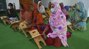 Anggota komunitas transgender belajar membaca Alquran di dalam Madrasah Dawatul Islam Tritio Linger untuk jenis kelamin ketiga, di Dhaka, Bangladesh, Selasa (17/11/2020). Ibu kota Bangladesh, Dhaka membuka madrasah pertama untuk transgender muslim pada 6 November 2020 lalu. (Munir Uz zaman/AFP)
