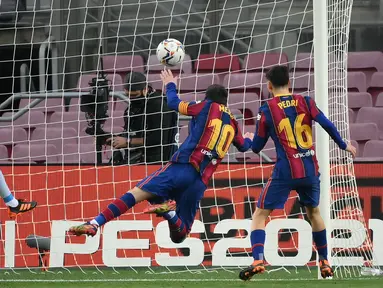 Striker Barcelona, Lionel Messi (kedua dari kanan), mencetak gol pertama timnya lewat sundulan kepala ke gawang Valencia dalam laga lanjutan Liga Spanyol 2020/21 di Camp Nou Stadium, Barcelona, Sabtu (19/12/2020). Barcelona bermain imbang 2-2 dengan Valencia. (AFP/Lluis Gene)