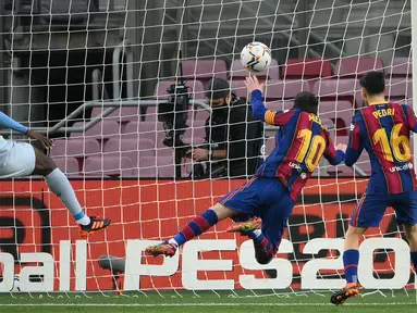 Striker Barcelona, Lionel Messi (kedua dari kanan), mencetak gol pertama timnya lewat sundulan kepala ke gawang Valencia dalam laga lanjutan Liga Spanyol 2020/21 di Camp Nou Stadium, Barcelona, Sabtu (19/12/2020). Barcelona bermain imbang 2-2 dengan Valencia. (AFP/Lluis Gene)