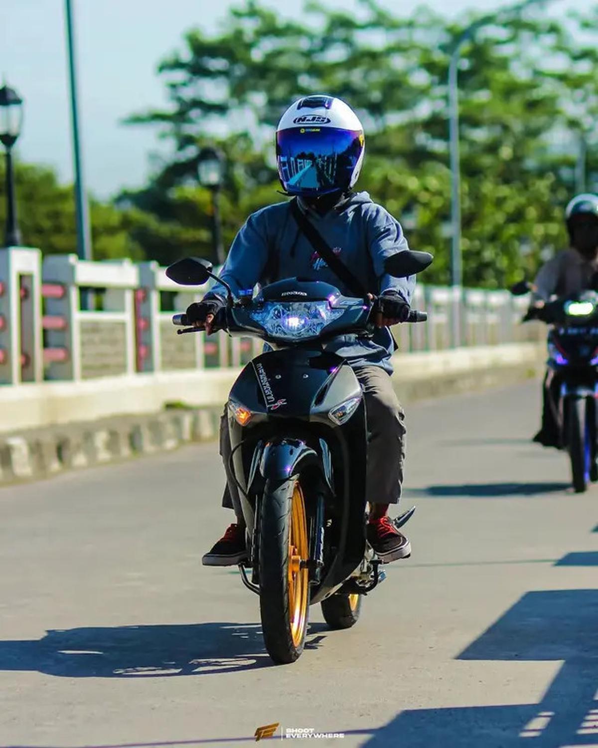 Supra X ini tampil simpel tapi keren banget! Warna bodi hitam dan velg emasnya bikin mata nggak bisa berhenti memandang. Instagram/@sx.wave125i