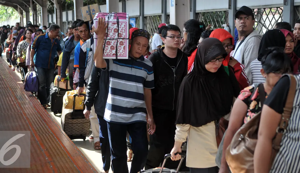 Pemudik membawa barang bawaannya berjalan menuju pintu kedatangan saat tiba di Stasiun Senen, Jakarta, Sabtu (9/7). Puncak arus balik pemudik di stasiun Senen diperkirakan terjadi pada besok Minggu (10/7). (Liputan6.com/Johan Tallo)