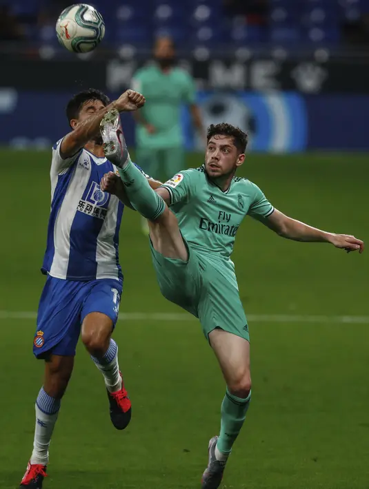 Pemain Real Madrid Federico Valverde (kanan) berduel dengan pemain Espanyol Didac Vila pada pertandingan La Liga Spanyol di Stadion Cornella-El Prat, Barcelona, Spanyol, Minggu (28/6/2020). Real Madrid menang 1-0 dan menggeser Barcelona dari puncak klasemen. (AP Photo/Joan Monfort)