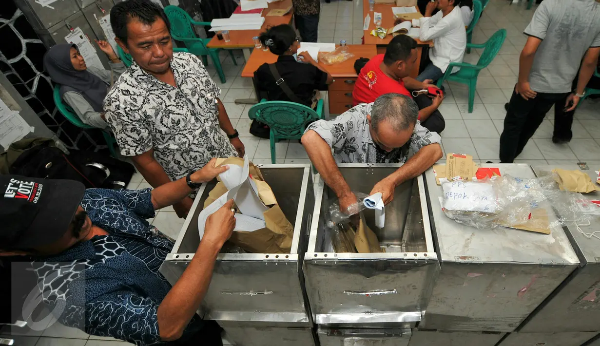 Petugas melakukan proses rekapitulasi surat suara Pilkada Depok 2015 di Kecamatan Pancoran Mas, Depok, Jumat (11/12). Rekapitulasi penghitungan surat suara tingkat kecamatan ini akan berlangsung dari 10-16 Desember mendatang. (Liputan6.com/Yoppy Renato)