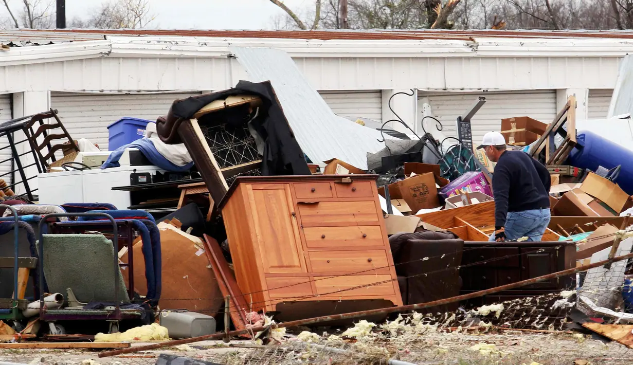 Seorang pria saat mencari barang yang masih dipakai di reruntuhan rumah, Texas, Amerika Serikat, (28/12). Diperkirakan kecepatan amgin ini mencapai 322 km per jam dan mengahancurkan apa yang dilewatinya. (REUTERS/Todd Yates)