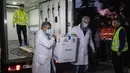 Petugas kesehatan membawa kotak berisi vaksin COVID-19 dari Pfizer saat tiba untuk pertama kalinya di Kryoneri village, dekat Athena, Yunani, Sabtu (26/12/2020). Gelombang pertama vaksin untuk melawan COVID-19 tiba di Yunani. (AP Photo/Yorgos Karahalis)
