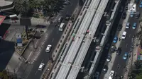Kendaraan melintas di bawah proyek pembangunan Light Rail Transit (LRT) Jabodebek di Rasuna Said, Kuningan, Jakarta, Rabu (21/8/2019). Jadwal pengoperasian LRT Jabodebek molor dari target yang pada awalnya direncanakan bisa beroperasi pada 2019. (Liputan6.com/Angga Yuniar)