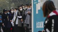 Wanita yang memakai masker wajah mengantre untuk mendapatkan tes usap tenggorokan COVID-19 rutin mereka di tempat pengujian virus corona di Beijing, Rabu (26/10/2022). Kota Shanghai di China mulai memberikan vaksin COVID-19 yang dapat dihirup pada hari Rabu di tempat yang tampaknya menjadi yang pertama di dunia. (AP/Andy Wong)