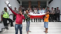 Petugas kepolisian mengamati aksi nelayan yang membawa miniatur kapal ke PTTUN di Cikini, Jakarta, Selasa (30/8). Para nelayan meminta hakim PTTUN menolak banding penerbitan izin reklamasi pulau G. (Liputan6.com/Immanuel Antonius)