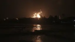Langit bersinar dari api yang melalap kilang minyak milik Pertamina, di Cilacap, Jawa Tengah, Sabtu (13/11/2021). Kebakaran kilang minyak tersebut membuat puluhan warga yang tinggal di dekatnya dievakuasi. (AP Photo/Agus Fitrah)