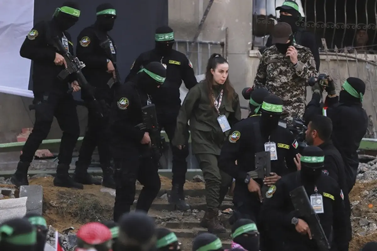 Tentara perempuan Israel, Agam Berger, dikawal para anggota Hamas saat menuju penyerahannya kepada Palang Merah, Kamis (30/1/2025).