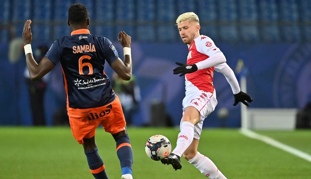 Bek AS Monaco, Caio Henrique (kanan) menguasai bola di hadapan bek Montpellier, Junior Sambia dalam laga lanjutan Liga Prancis 2020/21 pekan ke-20 di Mosson Stadium, Montpellier, Jumat (15/1/2021). AS Monaco menang 3-2 atas Montpellier. (AFP/Pascal Guyot)
