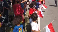 Memegang bendera mera putih, warga Kabupaten Sikka antusias menunggu kedatangan Presiden Joko Widodo. (Liputan6.com/Dionisius Wilibardus)