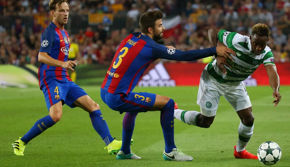 Gelandang Celtic, Moussa Dembele (kanan) berusaha melewati bek Barcelona, Gerard Pique pada Liga Chmapions Grup C di Stadion Camp Nou, Spanyol (14/9). Barcelona menang atas Celtic dengan skor 7-0. (REUTERS/Paul Hanna)