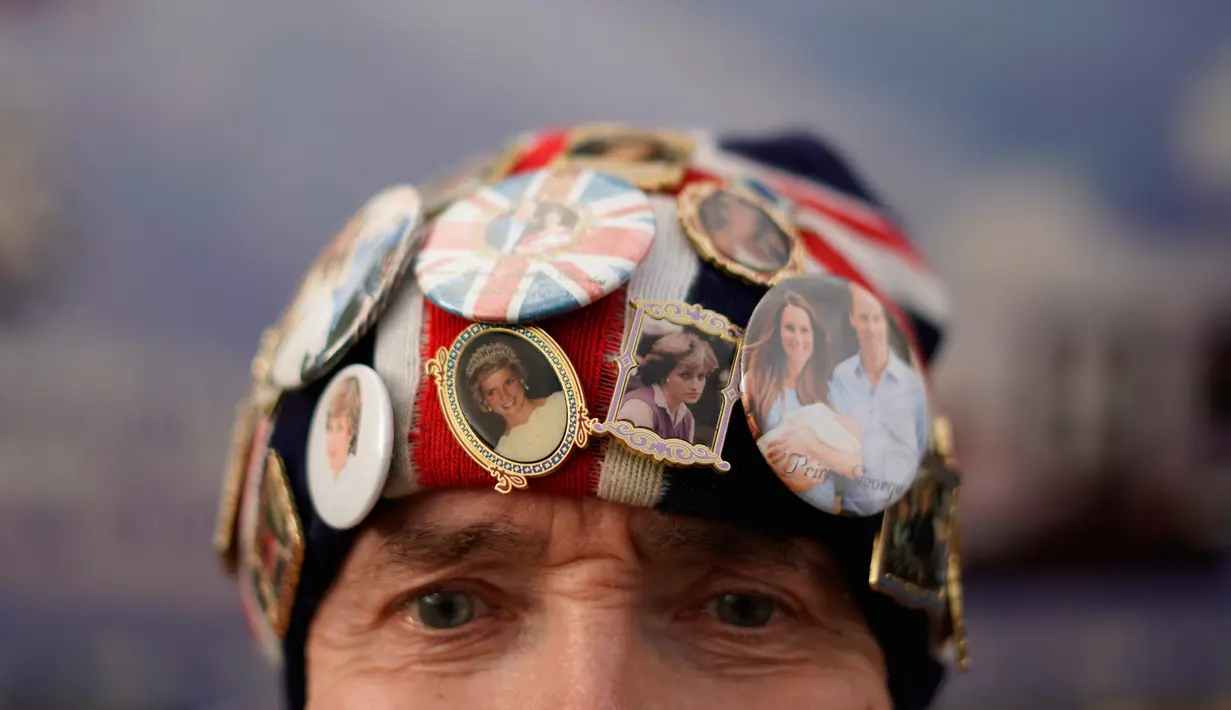 Penggemar royalti, John Laughrey, mengenakan topi dengan pin yang menggambarkan Putri Diana saat dia berdiri di luar gerbang Istana Kensington, London, Selasa (30/8/2022). Minggu ini menandai peringatan 25 tahun kematian Putri Diana dalam kecelakaan mobil di Paris. (AP Photo/Alberto Pezzali)