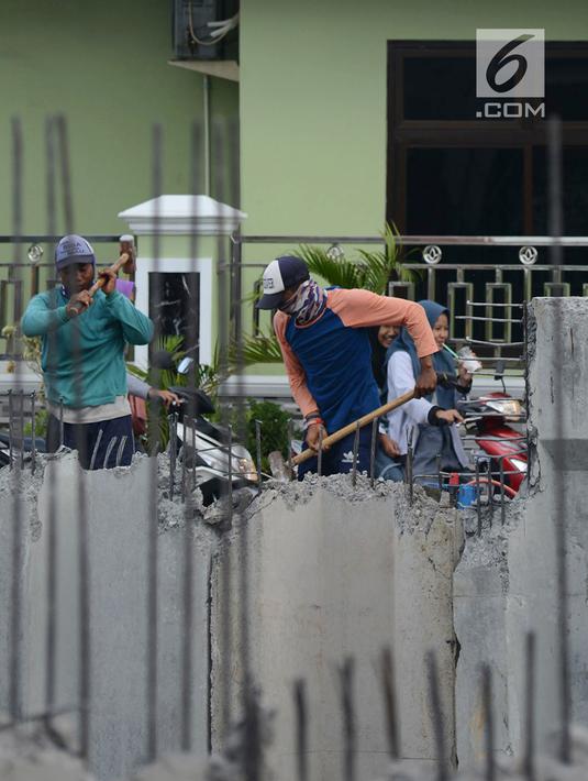 Pekerja membongar bangunan saat memasang turap di Kali Item, Jakarta, Rabu (2/1). Turap sepanjang 1.900 meter pada sisi kanan dan kiri kali untuk mengantisipasi genangan dan banjir di kawasan tersebut pada musim hujan. (Merdeka.com/Imam Buhori)