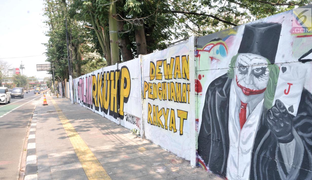 Mural bertulis '#TolakRKUHP dan Dewan Pengkhianat Rakyat' terpampang pada dinding di Jalan Pemuda, Rawamangun, Jakarta, Selasa (1/10/2019). Mural tersebut respons dari seniman Jakarta terhadap RUU KUHP yang dinilai mencederai tatanan demokrasi. (merdeka.com/Iqbal Nugroho)