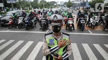 Petugas gabungan Polisi dan pengguna jalan Mengheningkan sejenak di Kawasan Jalan Fatmawati Jakarta, Sabtu (10/7/2021). Kegiatan mengheningkan cipta selama 60 detik tersebut bentuk penghormatan kepada mereka yang telah wafat karena covid-19. (Liputan6.com/Faizal Fanani)