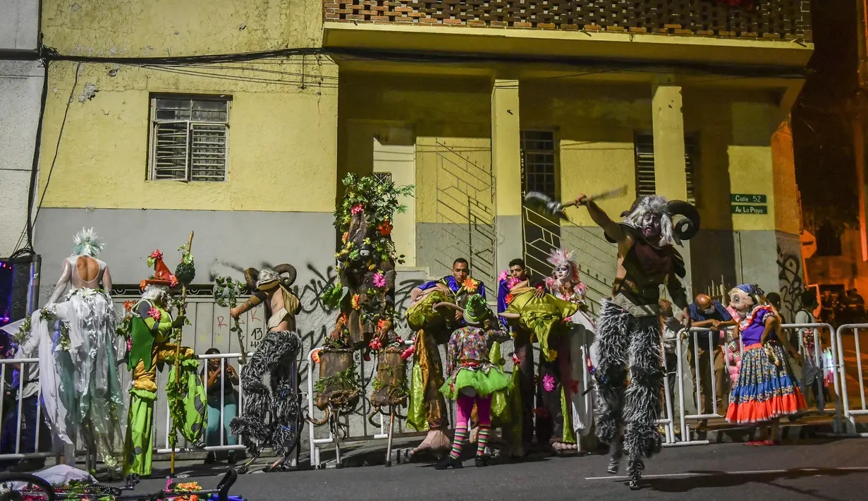Orang-orang yang bersuka ria tampil selama parade Mitos dan Legenda di Medellin, departemen Antioquia, Kolombia (8/12/2021). Parade mitos dan legenda adalah bagian penting dari acara ini di sebagian besar kota dan kotamadya Kolombia. (AFP/Joaquin Sarmiento)