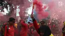 Sejumlah buruh menyalakan bom asap saat menutup aksi Hari Buruh Internasional di Jalan Medan Merdeka Barat, Jakarta, Rabu (5/1/2019). Buruh dari berbagai organisasi merayakan Hari Buruh Internasional di Kawasan Silang Barat Daya Monas. (Liputan6.com/Helmi Fithriansyah)
