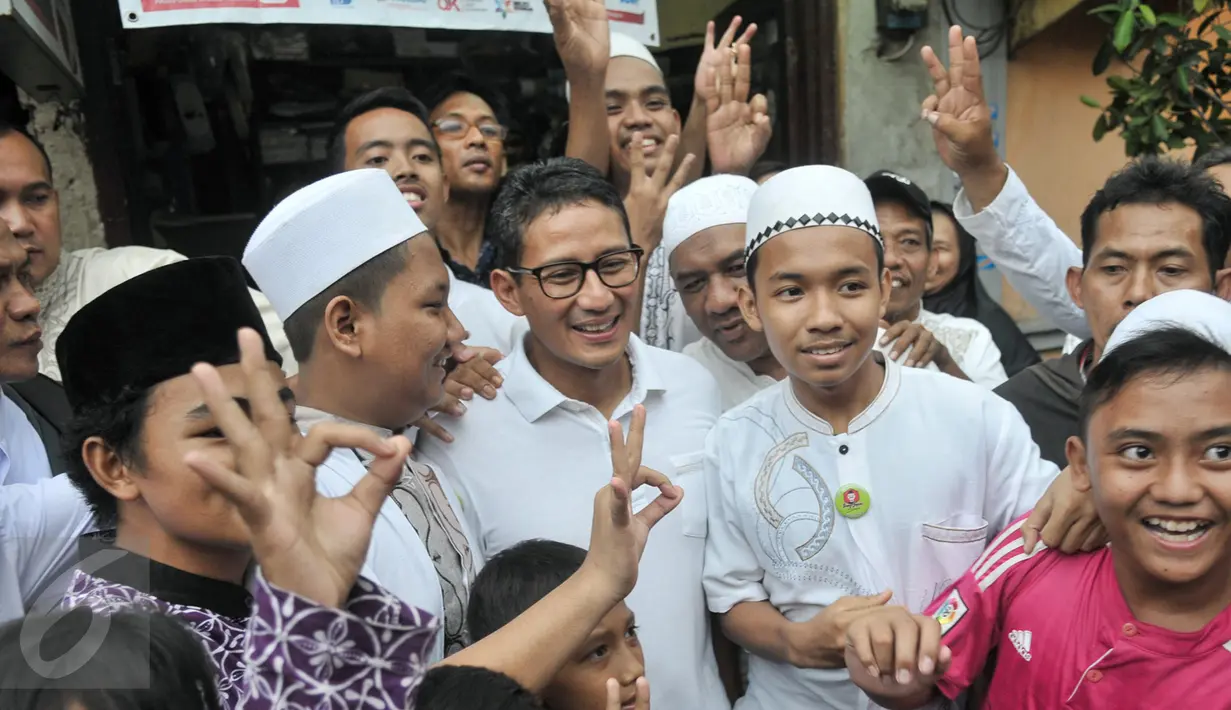 Cawagub DKI Jakarta, Sandiaga Uno foto bersama warga saat sosialisasi kampanye di Petojo Binatu, Jakarta Pusat, Jumat (17/3). Selain meminta dukungan dan doa, Sandiaga memaparkan program KJP Plus ke warga bila terpilih nanti. (Liputan6.com/Yoppy Renato)