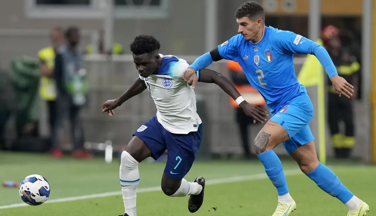 <p>Gelandang Inggris, Bukayo Saka berusaha melewati pemain Italia, Giovanni Di Lorenzo selama pertandingan UEFA Nations League di stadion San Siro, di Milan, Italia, Jumat, 23 September 2022. Skuad asuhan Gareth Southgate itu terbenam di dasar klasemen Grup C Liga A dengan 2 poin dari lima pertandingan. (AP Photo/Antonio Calanni)</p>