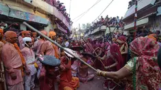 Sejumlah wanita memukul pria dengan tongkat (lathi) selama perayaan Lathmar Holi di Barsana di Mathura, India, (24/2). Lathmar Holi adalah perayaan lokal festival Hindu Holi, biasanya beberapa hari sebelum festival Holi. (AFP Photo/Dominique Faget)