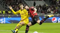 Olivier Giroud dari AC Milan, kanan, berebut bola dengan pemain Dortmund Nico Schlotterbeck pada pertandingan sepak bola grup F Liga Champions antara AC Milan dan Borussia Dortmund di stadion San Siro di Milan, Italia, Selasa, 28 November 2023. (AP Photo /Antonio Calanni)