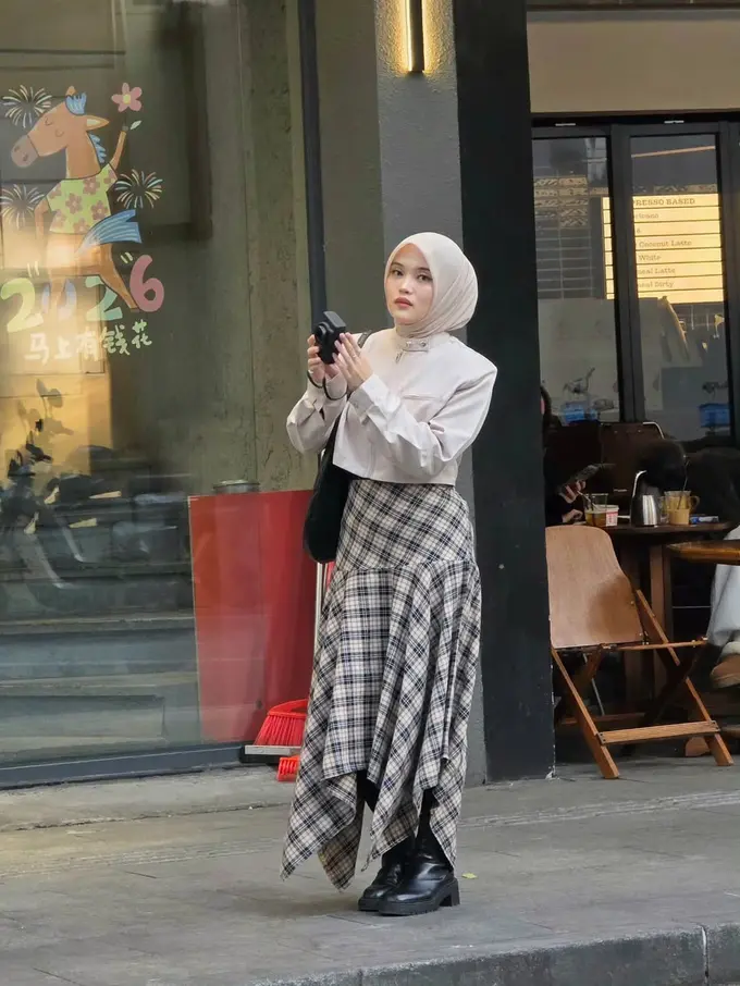 Gaya Modest Preppy Delina Putri Liburan di China dengan Rok Tartan dan Cropped Jacket