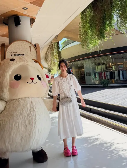 Ia juga mengenakan long dress putih lengan puff panjang dipadukan sandal wedges jelly warna fushcia.  [@limjjy2]