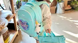 Sang ibunda juga kerap berbagi aktivitas Han Yeoreum saat pergi ke sekolah. Ia tampil menggemaskan dengan satu set tas punggung dan tas tenteng berwarna biru cerah. Rambut cokelatnya yang panjang dan berponi membuat 'baby Sol' semakin manis diusianya saat ini. (Liputan6.com/IG/@k_han__na)