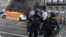 <p>Plakat bertuliskan "Polisi antihuru-hara, pergi" ditempatkan pada mobil yang terbakar saat polisi antihuru-hara mengamankan demonstrasi di Rennes, Prancis, Kamis (13/4/2023). (AP Photo/Mathieu Pattier)</p>