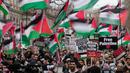 Para pengunjuk rasa pro-Palestina memegang spanduk, bendera, dan plakat saat berunjuk rasa di London, Sabtu, 3 Februari 2024. (AP Photo/Kin Cheung)